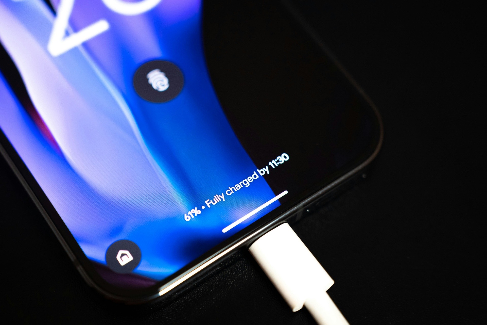 A phone on a desk with a USB cable plugged in